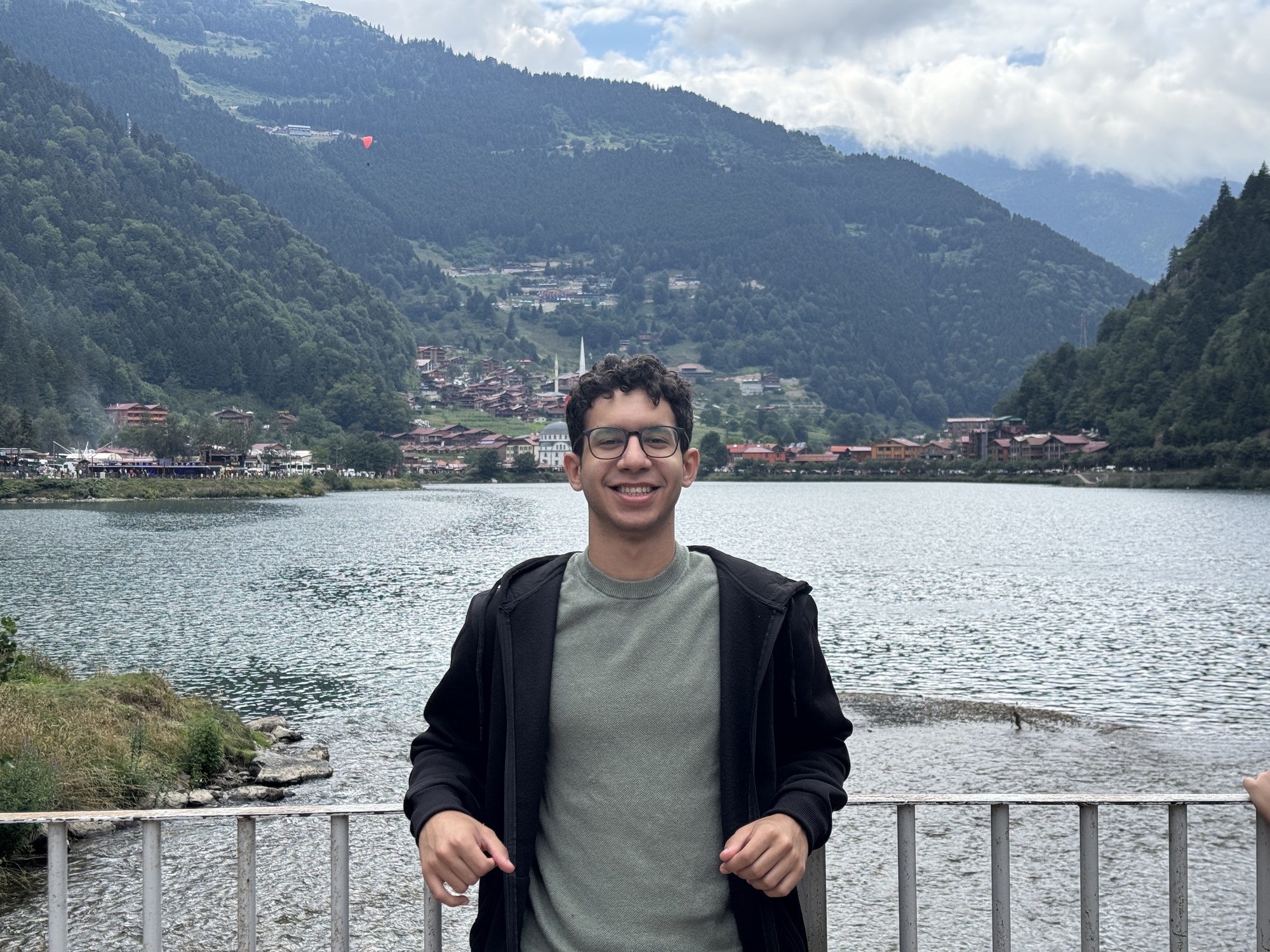 Badr Elgezeri standing in front of a mountain lake